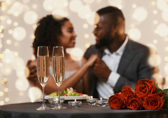 African american couple in love cuddling in restaurant