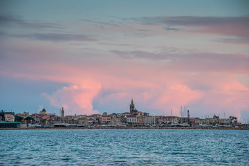 Fototapeta premium Pink clouds over Alghero at sunset