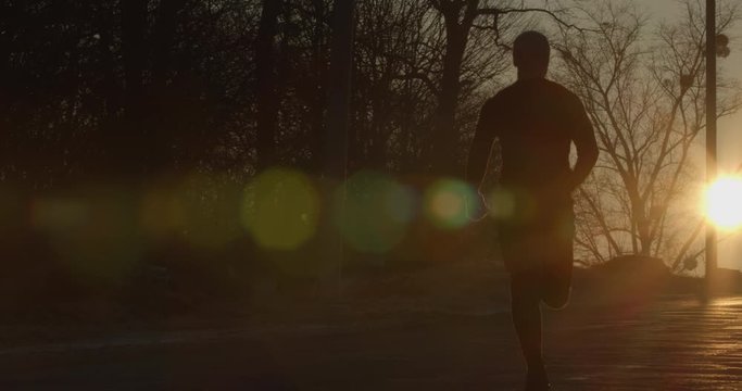 A guy is running down the road at dawn. Cold weather. 4k 