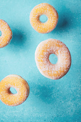 Donuts on turquoise background. Top view, copy space.