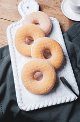 Doughnuts donut with sugar on wooden table.