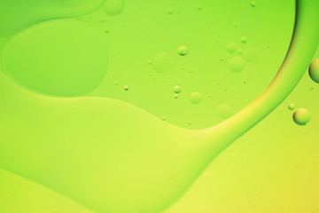 Oil drops in water. Defocused abstract psychedelic pattern image green and yellow gradient colored....