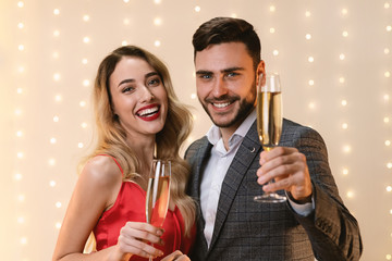 Cheers. Romantic Couple Posing With Champagne Glasses, Greeting With Holidays