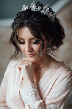 Beautiful woman posing in robe. Wedding makeup and hairstyle with diamond crown, fashion bride model jewelry and beauty female face, bride.
