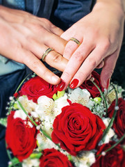Obraz na płótnie Canvas Hands rings and red roses 