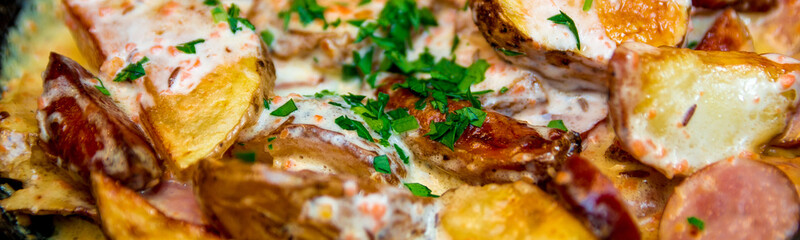 Banner of Oven baked potatoes with cream and cheese in black in a frying pan