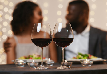 Selective focus on two glasses of wine over black couple