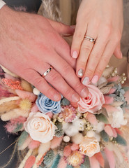 Obraz na płótnie Canvas Wedding rings on a bouquet of dried flowers