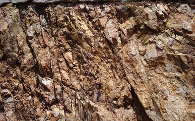 Rocks outcrop with geology hammer