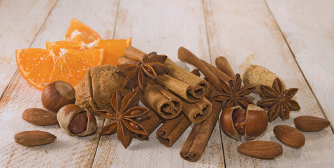 image of anise, cinnamon, almond nut, orange slices on the table