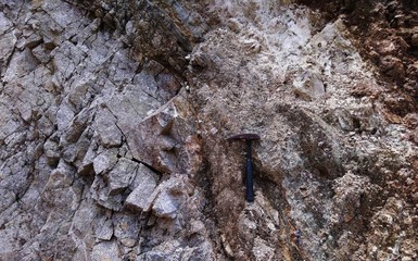 Rocks outcrop with geology hammer