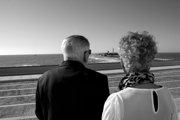 Dos personas mayores mirando al mar.