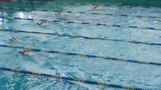 Men Swimmers In A Swimming Training In A Specially Equipped Large Pool With Diving Goggles And Caps. Synchronized Backstroke.