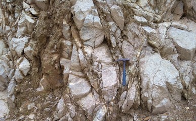 Granitic rocks outcrop with geology hammer