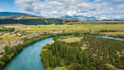 Naklejka na ściany i meble Turquoise river with a green trees and meadows