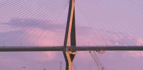 puente colgante con un atardecer rosaceo y nubes de fondo