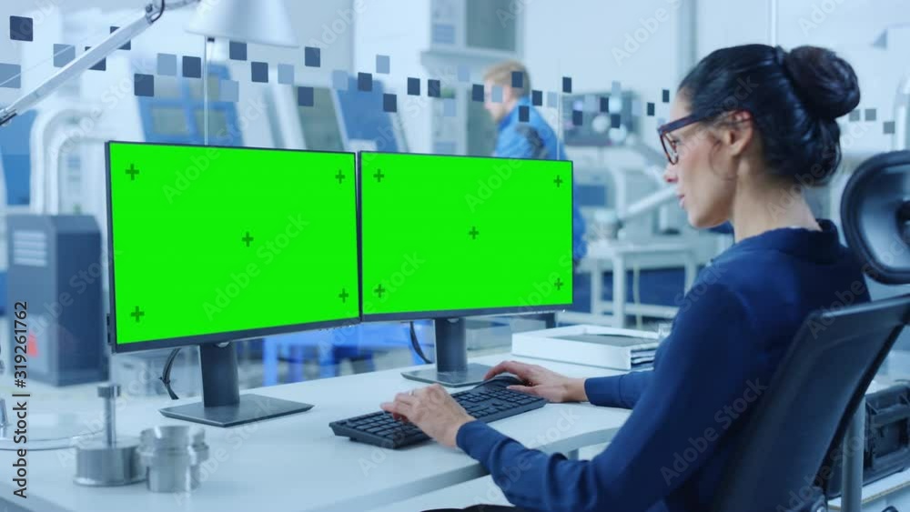 Poster industrial female engineer working on a personal computer, two monitor screens are mock-up, green sc