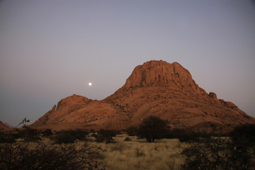 wschód księżyca nad górą spitzkoppe w górach pontoku w namibii