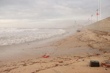 The stormy sea washed the sand off the beach. Garbage on the beach.