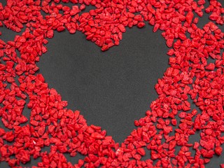 Copy space heart shape on blackboard texture with vivid or vibrant red gravel pattern for valentine 's day and love background concepts and ideas.