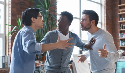 Multiracial coworkers having quarrel in office, conflict of interest - obrazy, fototapety, plakaty