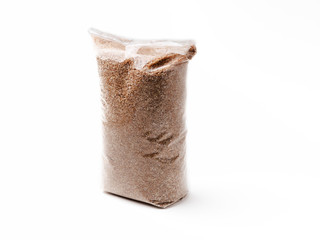 Wheat grits in a transparent plastic bag, isolate white background