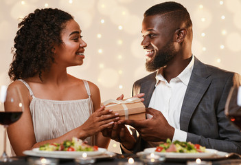 Black man giving his girlfriend beautiful box of present