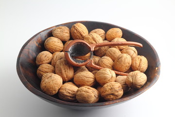 walnuts in a bowl isolated on white background. with nutcracker. 