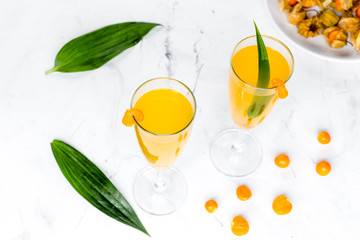 cocktail with physalis in glass on stone background