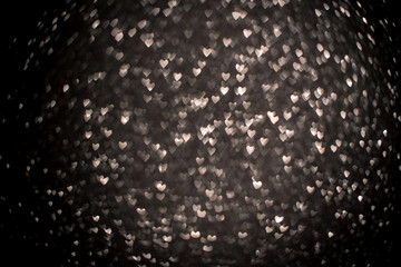 Background with silver bokeh in the shape of a heart.