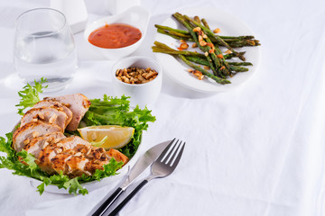 Grilled chicken breast with grilled asparagus and lemon slice. Paleo diet. Healthy nutrition. Concept for a tasty and healthy meal.