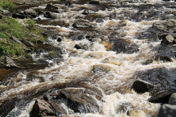 Fast Flowing Shallow River Running Over Rocky Rapids.