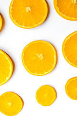 slices of oranges on white background bright pattern top view