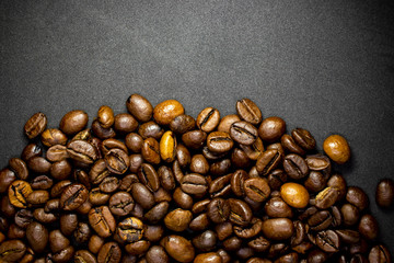 Coffee in beans on dark background. Abstract background texture.Coffee beans texture. Food background of coffee beans
