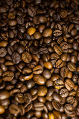 Dark background and texture of coffee beans, selective focus, closeup grains.