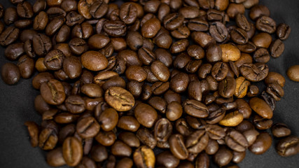 Dark background and texture of coffee beans, selective focus, closeup grains.