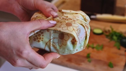 Woman hands demonstrating a healthy sandwich in beeswax food wrap