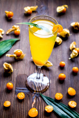 cocktail with physalis in glass on wooden background