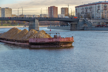 Fototapeta na wymiar Barge with sand on the river in the city