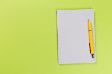 top view of blank open notebook or notepad on green background, office equipment, school supplies and education concept