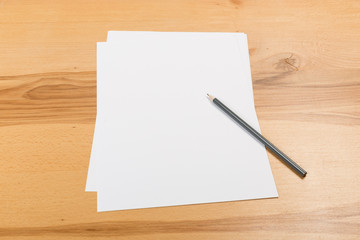 A4 white paper with pen on wooden background. Blank branding template. Photo blank form. Layout for portfolio design.