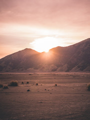 Couché de soleil rosé entre montagnes et désert