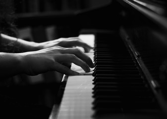 Fototapeta na wymiar Black and White Image of Hands on Piano Keys