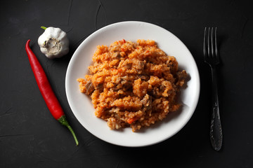 pilaf on a white plate, dark background