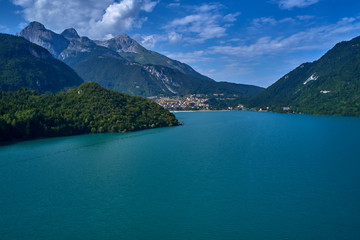Obraz na płótnie Canvas Aerial view of Lake Molveno, north of Italy in the background the city of Molveno, Alps, blue sky. Reflection of mountains in water. 