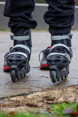 A portrait of feet in rollerblades of a person ready to start an inline skating race on a concrete...
