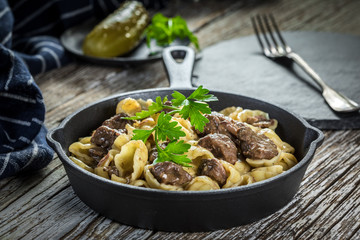 Italian pasta shells with beef sauce in cast iron pan.