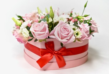 Beautiful valentiens day floral arrangement. Pink roses, white and green flower composition in a heart.