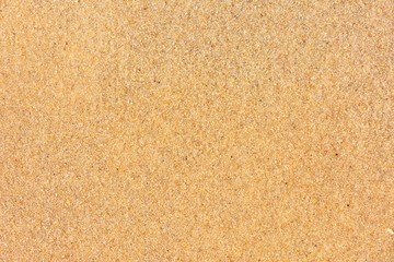 Naklejka na ściany i meble Golden sand background with selective focus. Textured yellow sand surface with soft focus. Summertime. Beach vacation. Seascape with clean sand. 