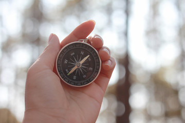 compass in hand on blue sky background